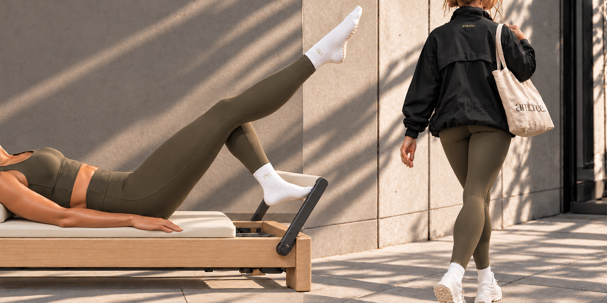 Du Reformer à la ville : ensemble olive, chaussettes de Pilates blanches, veste Nola noire et sac beige avec logo ambrée.